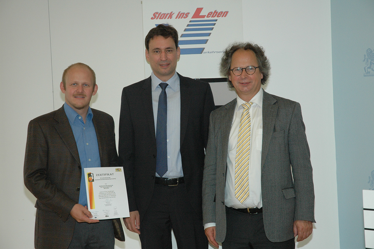 Schulleiter Hr. Keil und EVA-Beauftragter Hr. Müller bekommen von Staatsekretär Hrn. Georg Eisenreich im Kultusministerium Bayern die Zertifizierungsurkunde überreicht.